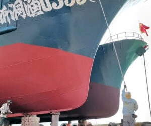 Incredible Worker Uses 20-Ft-Long Pole To Write A Ship’s Serial Numbers Without Scaffolding