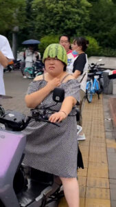 Read more about the article Woman Riding Scooter Uses Half Watermelon For Helmet