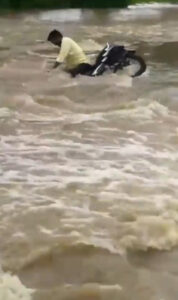 Read more about the article  Moment Man On Motorbike Is Swept Away Trying To Ride Across Flooded Road