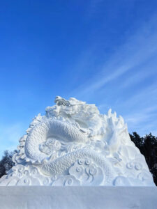 Read more about the article Participants At Winter Festival Carve Massive Dragon Sculpture